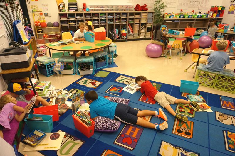 Students in classroom reading in various locations.