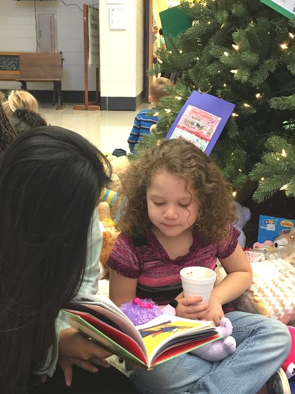 Female Sevier Middle student reading with female Paris Elementary student