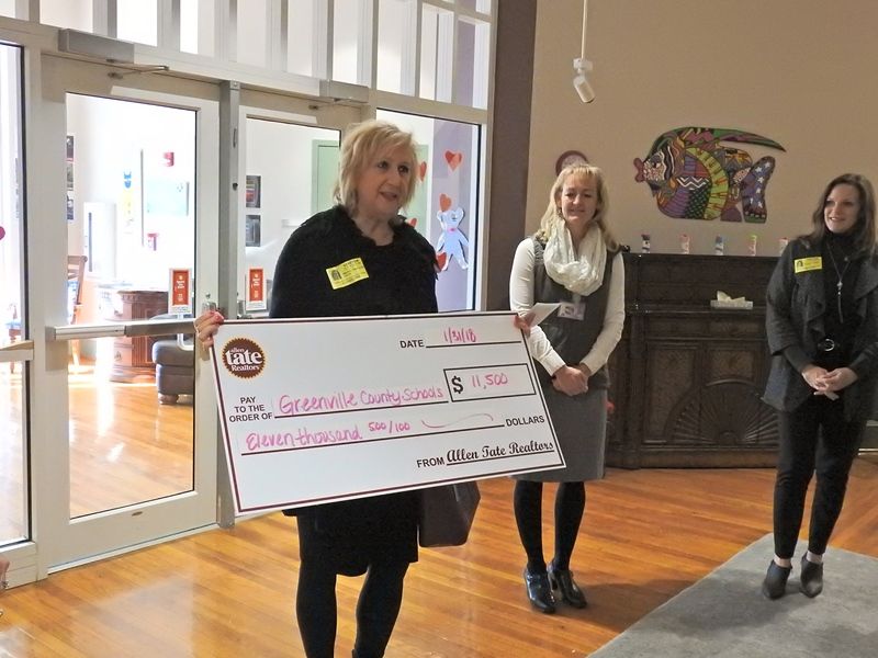 Martha Hayhurst from Allen Tate Greenville Downtown presents a check to Superintendent Royster. Overbrook CDC will receive some of the funds to build a new handicap-accessible playground.