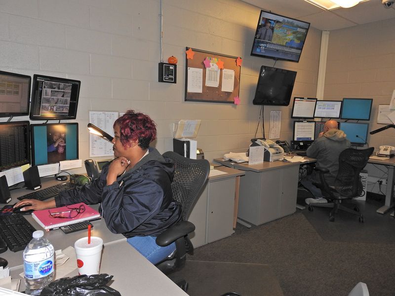 Female employee sitting at security monitors