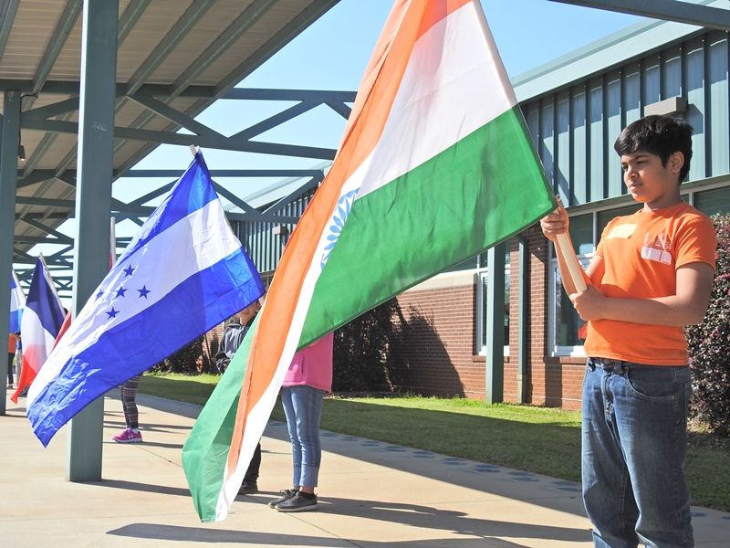Students holding country flags in the parade of nations