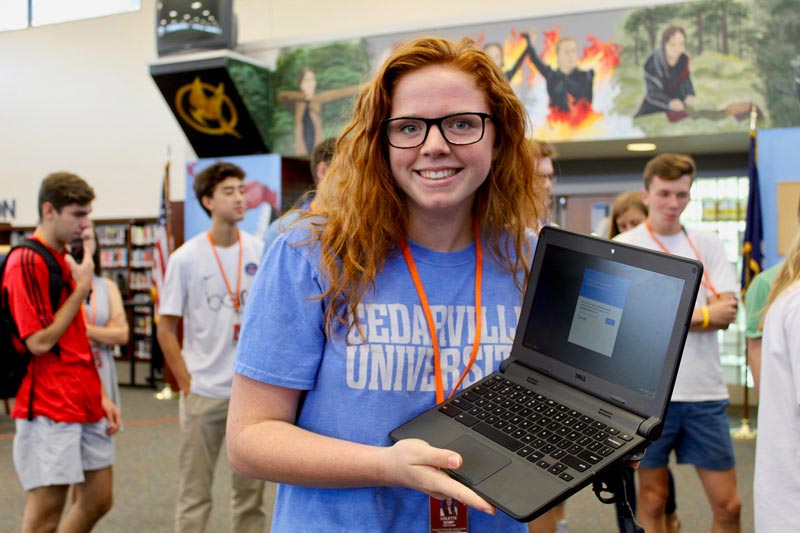 Girl holding a laptop computer at the college fair