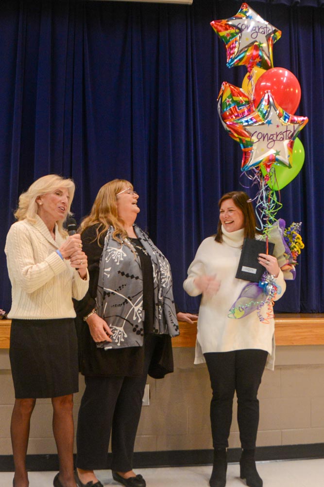 School Board Trustees Lynda Leventis-Wells and Debi Bush congratulate Principal Mary Leslie Anderson