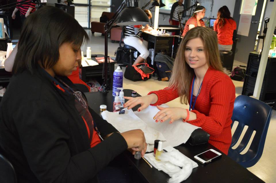 Female career center students -one doing the nails of the other