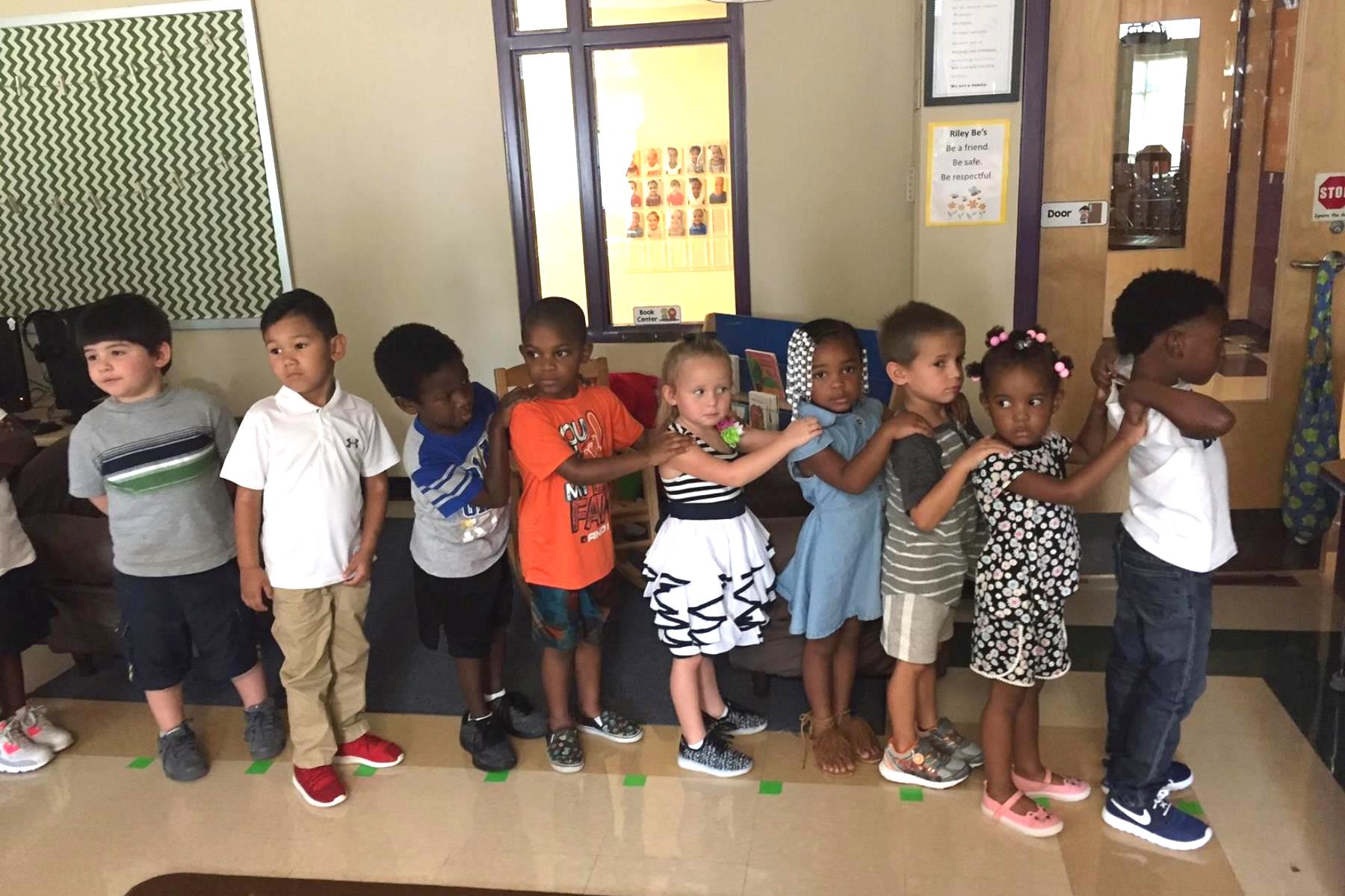 A group of pre-school children standing in a line