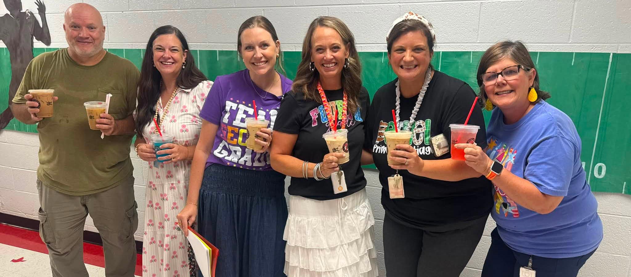 6 staff members holding Starbucks drinks