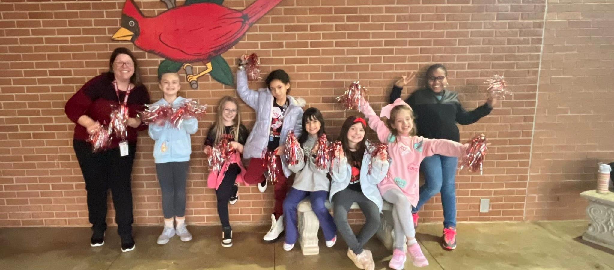 teacher with students outside by wall