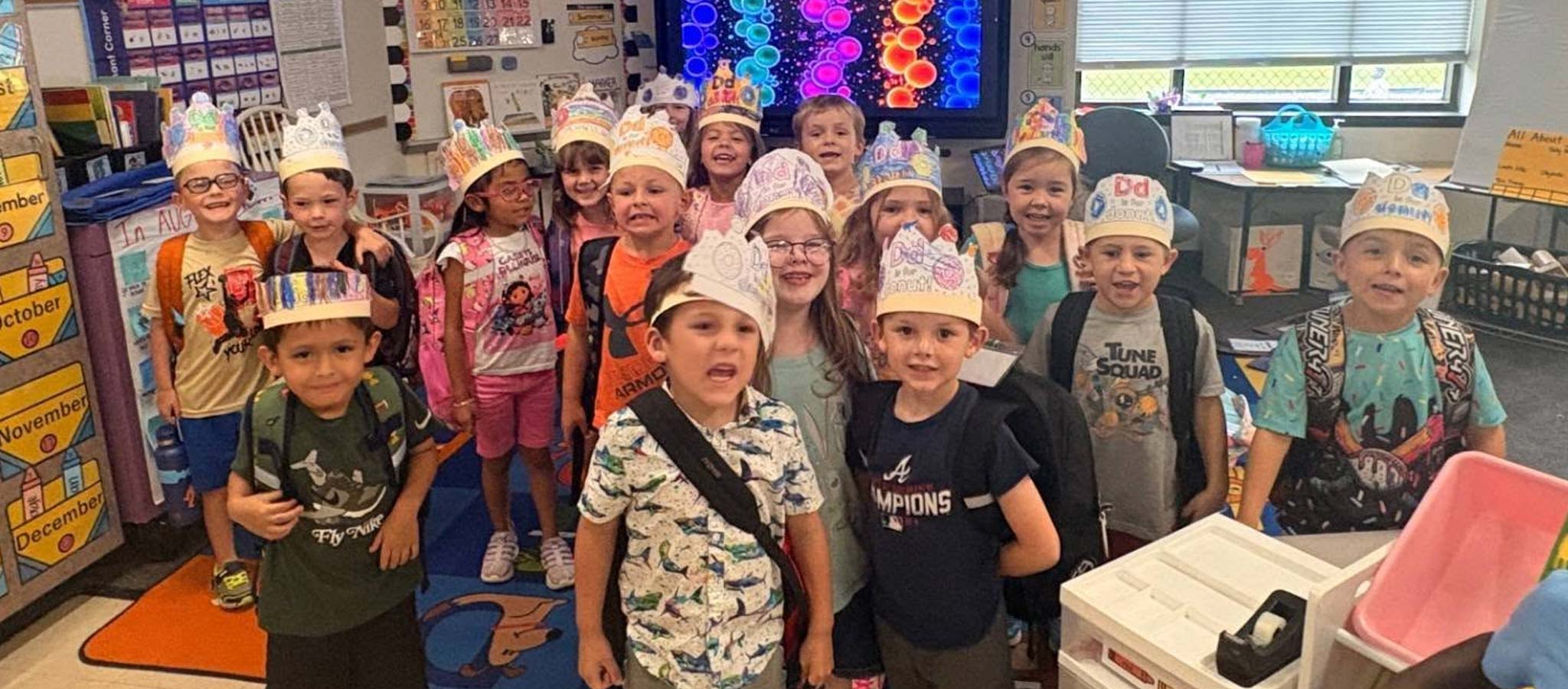 group of students in a classroom wearing handmade hats