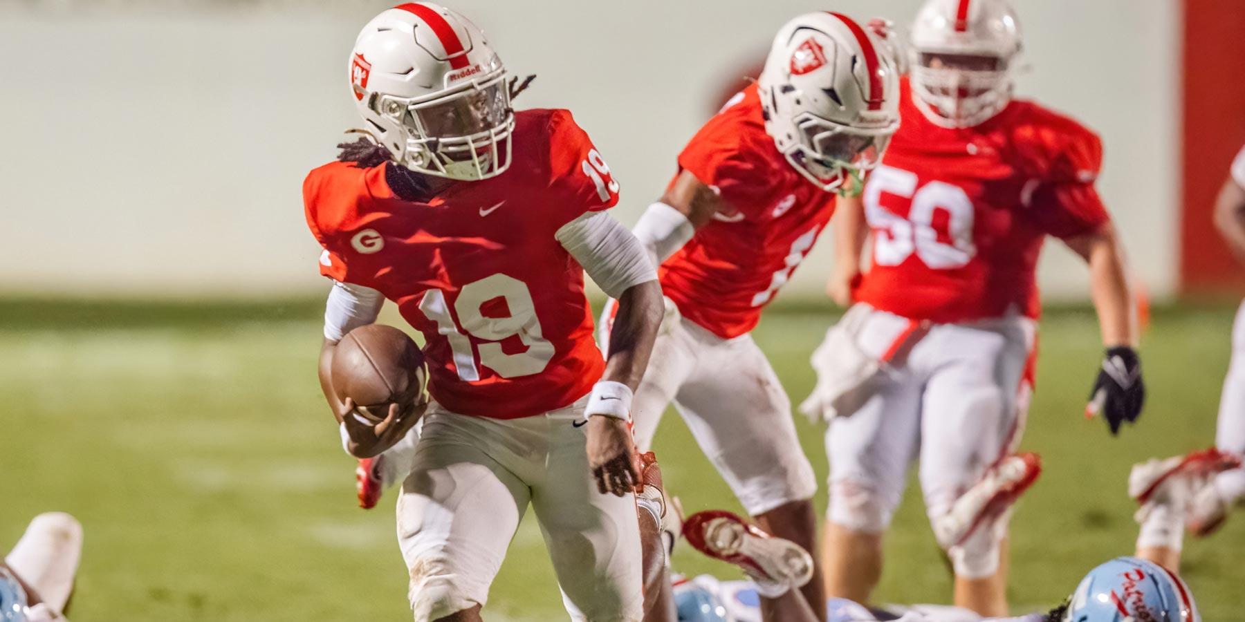 football player runs with the ball at the football game