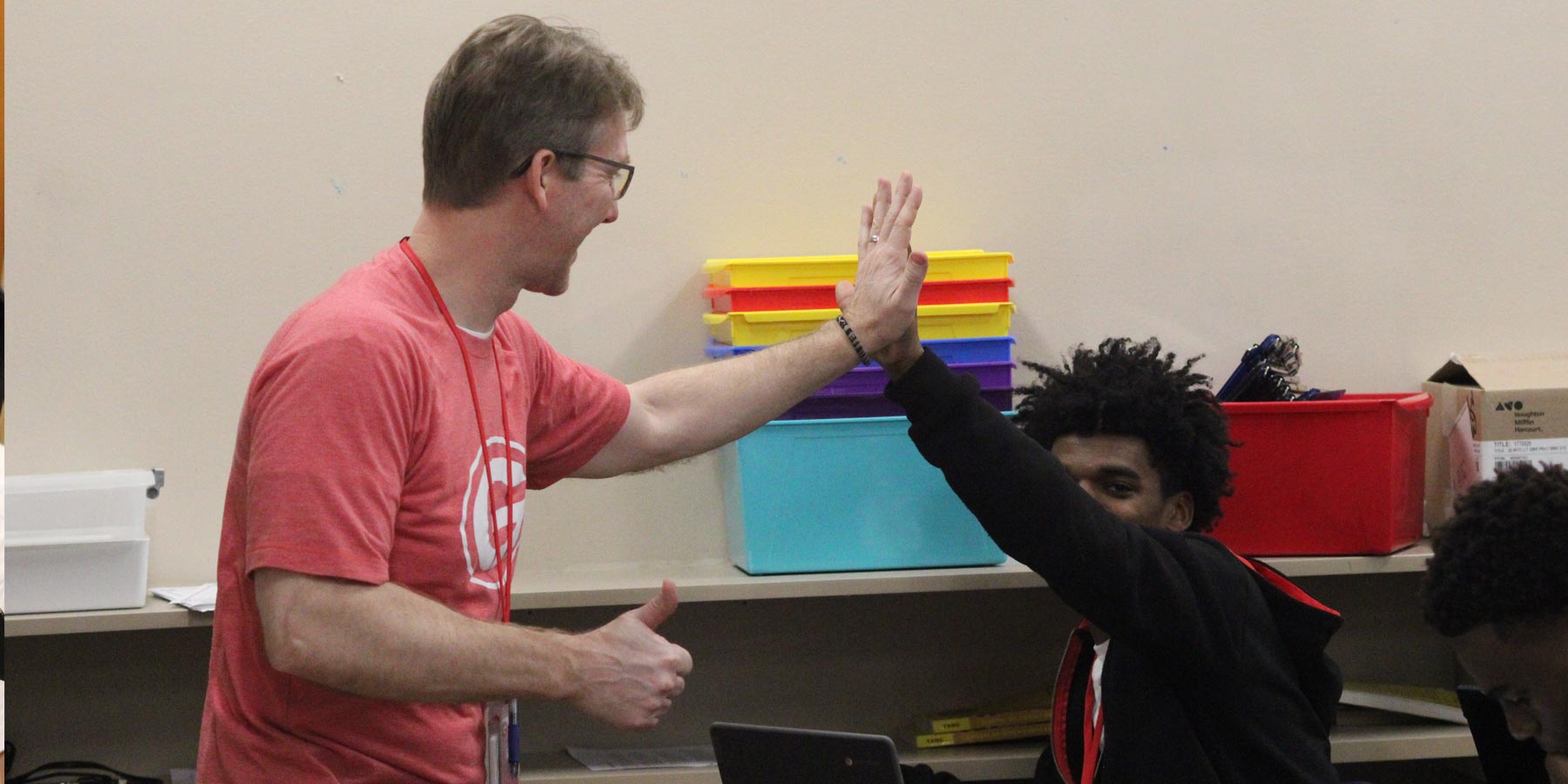 student and teacher high five during class