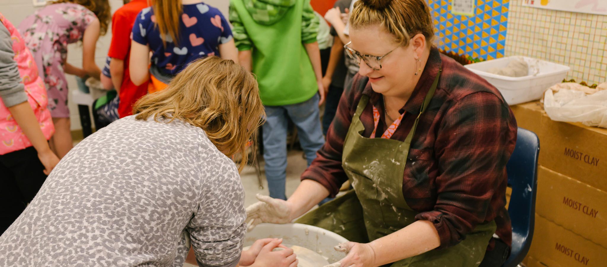 Teacher molding pottery clay
