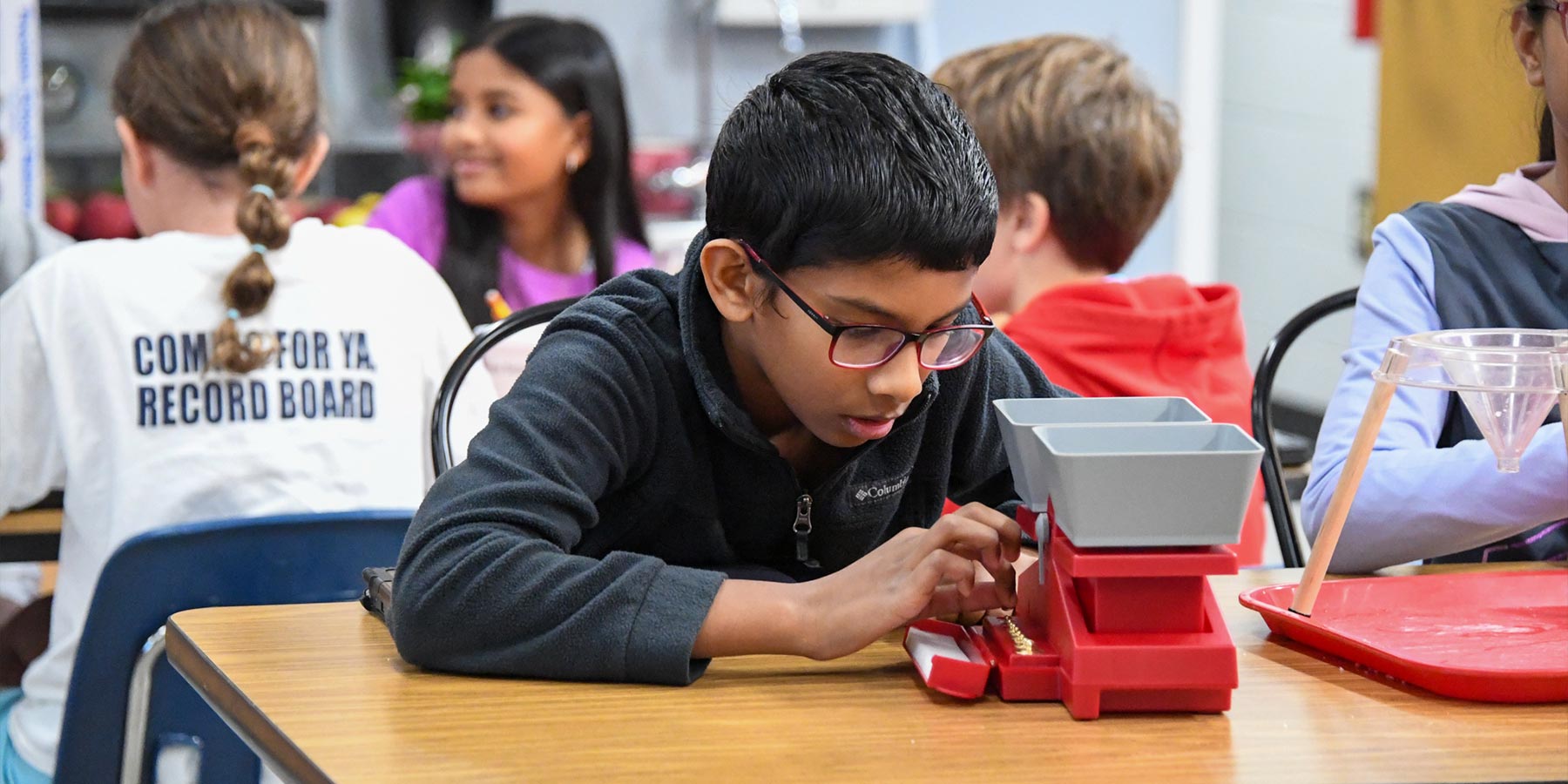 elementary student using a scale to measure