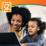 mother and daughter looking at a laptop screen together