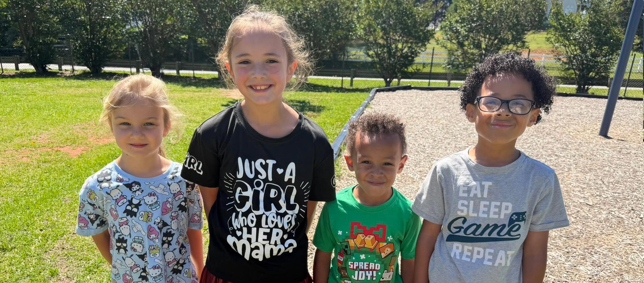 4 elementary students standing on a playground