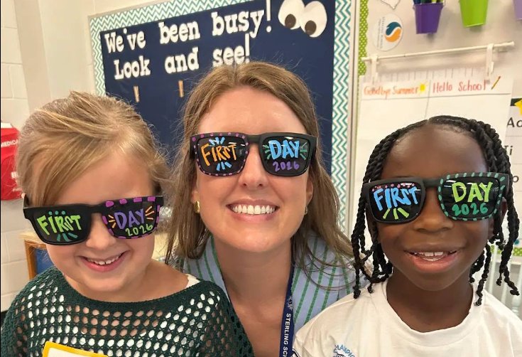 A Sterling teacher and two students wearing First Day 2026 sunglasses in a classroom