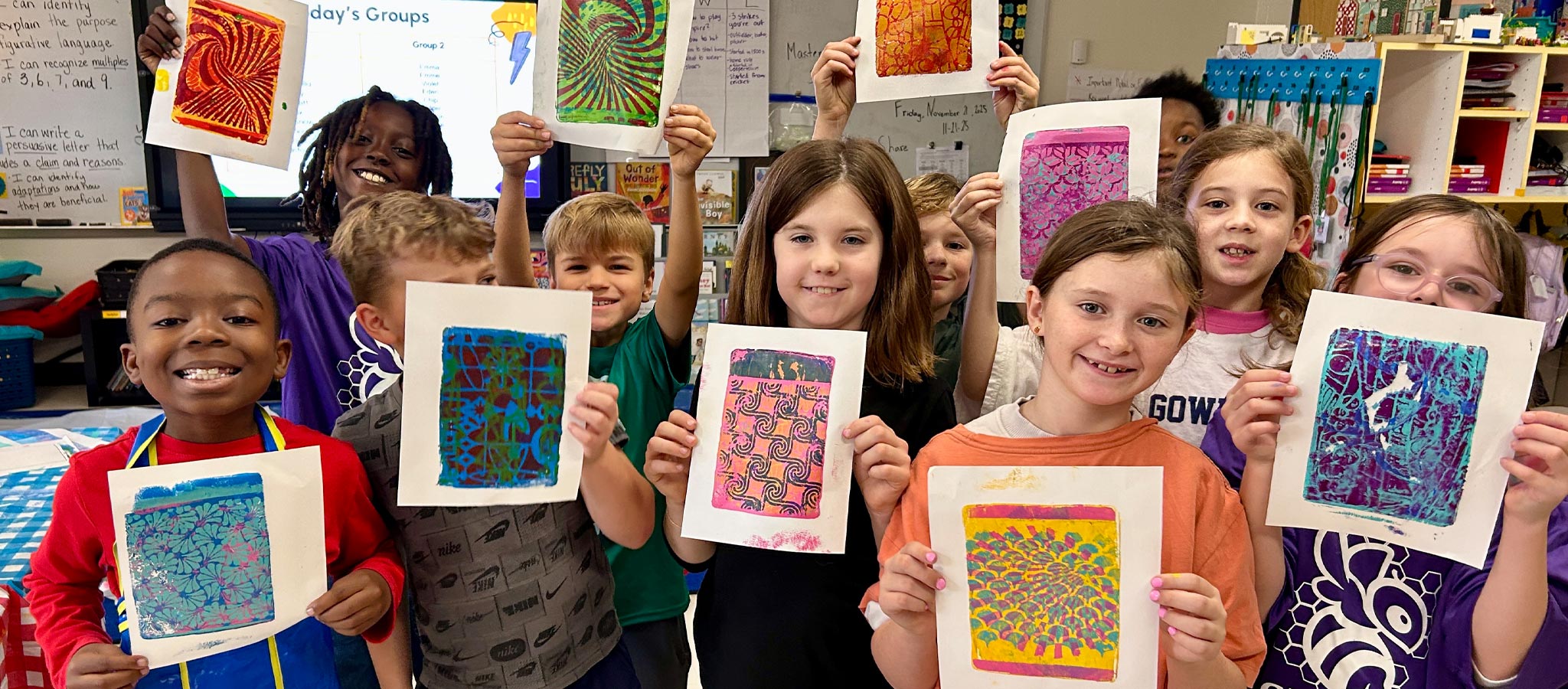 group of students holding up their artwork