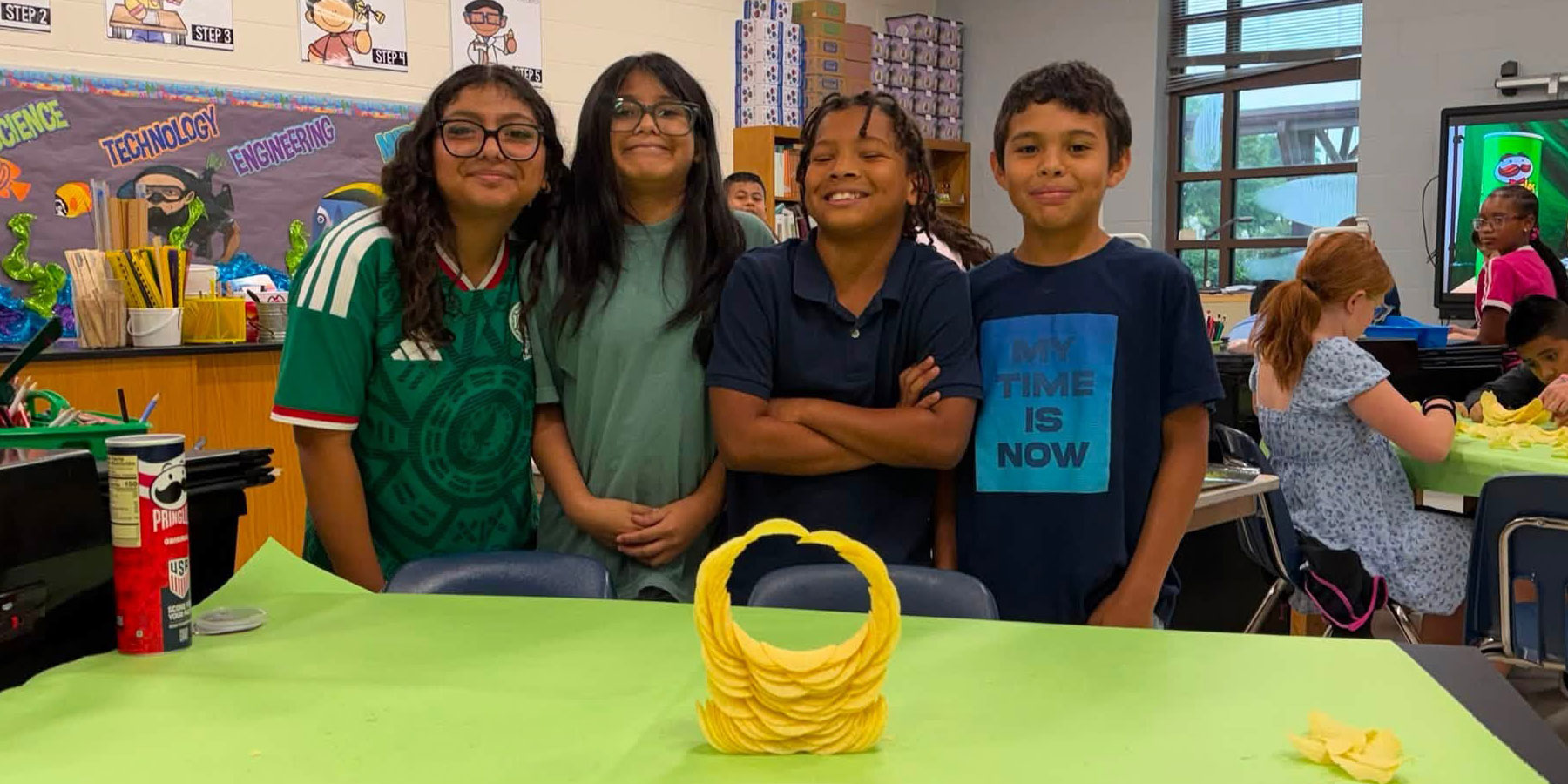 4 students with chip design in classroom