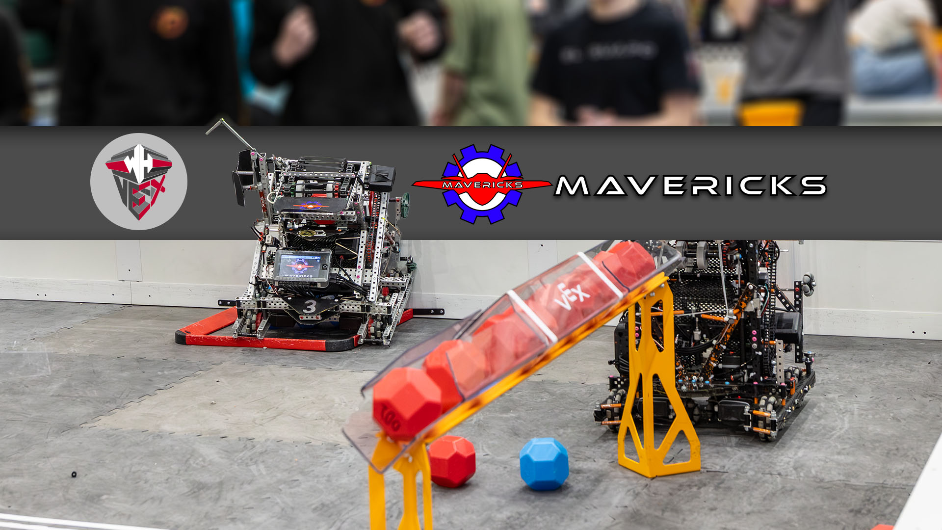A VEX robotics field with a robot on the left and a WHHS VEX Logo, the Mavericks Fighter-Jet Logo, and the word Mavericks